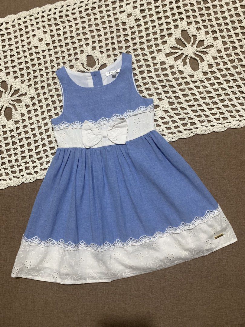 3T Tahari Dress (Category: Babies & Kids Fashion) located in Davao. Submitted by _declutterwithme30 (Listing ID 1438562956, Image 1). Description: - Adorable blue dress - Features white lace detailing - Cute bow accent at the waist - Sleeveless design - Flared skirt - Delicate lace trim at hem and waist - Made of lightweight fabric - Perfect for special occasions or everyday wear.