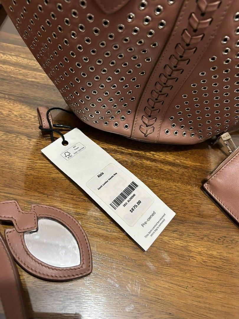 Authentic Alaïa Eyelet Leather Handle Bag (Pre-owned) (Category: Luxury Bags & Wallets) located in Taguig. Submitted by jjcollectivefinds (Listing ID 1438686621, Image 2). Description: please note there is noticeable wear/tearing on the leather loop connecting the strap hardware (see photos) ​.