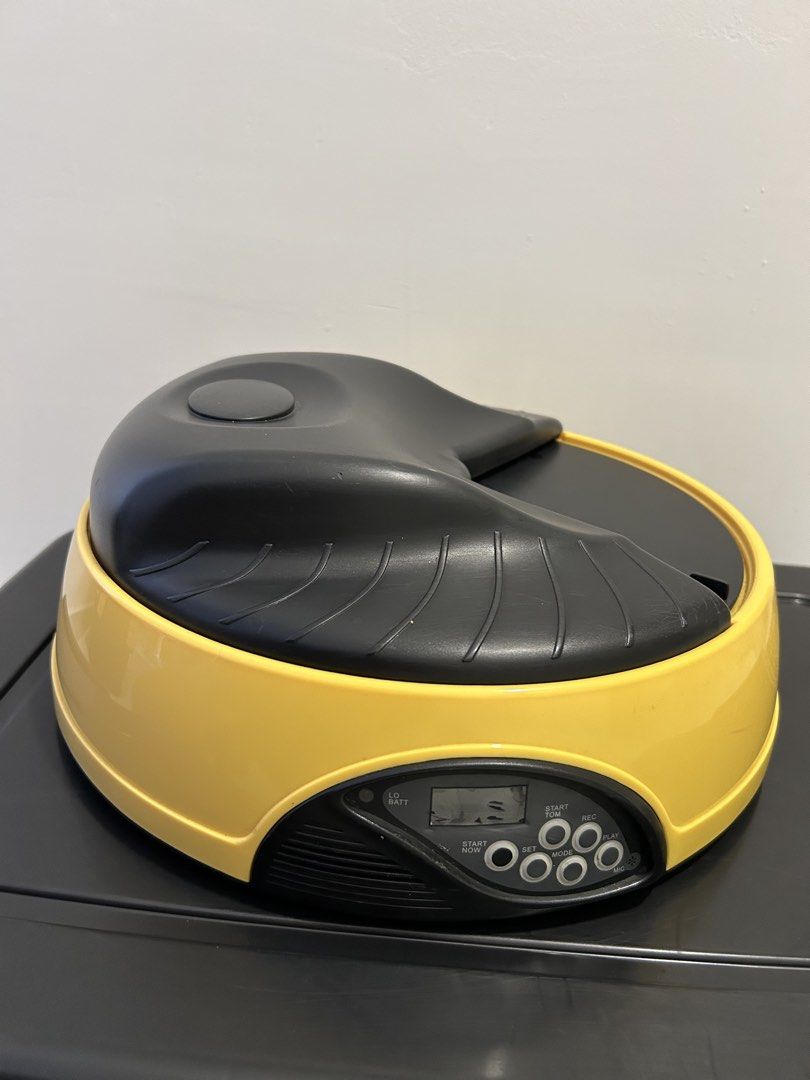 Automatic Pet Feeder (Category: Homes & Other Pet Accessories) located in Kuala Lumpur. Submitted by eureka86 (Listing ID 1438502313, Image 1). Description: - Automatic pet feeder - Yellow and black design - Digital display and control buttons - Round shape with black top and yellow base - Easy to set time and feeding schedule - Dispenses food automatically.