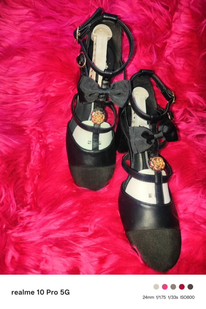Black Heels with Bows (Category: Heels) located in Manila. Submitted by cleverturtle-2982 (Listing ID 1438619316, Image 1). Description: - Black T-strap heels - Charming bow accents - Gold buckle closure - Round gold emblem - Darker, possibly suede, toe area - Stylish and chic design.