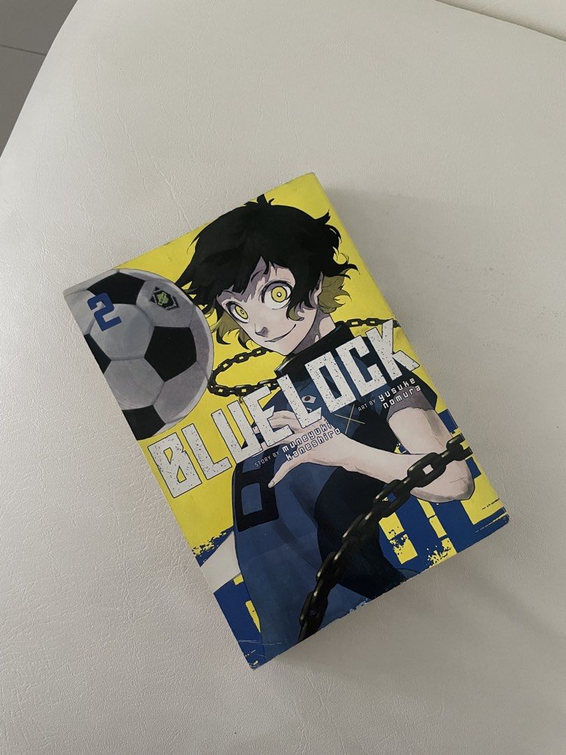 Blue Lock Manga Volume 2 (Category: Comics & Manga) located in Makati City. Submitted by kzisdeclutter (Listing ID 1438506122, Image 1). Description: - Blue Lock manga volume 2 - English edition - Story by Muneyuki Kaneshiro, art by Yusuke Nomura - Features a character with a soccer ball on the cover - Back cover includes a story summary and character images.