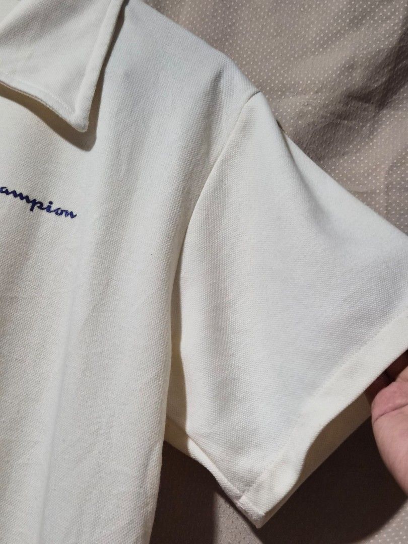 Champion Polo Shirt Oversized (Category: Tshirts & Polo Shirts ) located in Mandaue City. Submitted by chuchi152615 (Listing ID 1438683890, Image 3). Description: - Cream-colored Champion polo shirt - Features the Champion logo - Short sleeves - Collared neckline with 3 buttons - Measurements: 17 inches length, 22 inches width - Made of textured fabric.