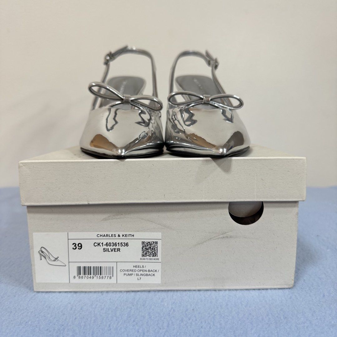 Charles & Keith C&K Silver Slingback Heels Size 39 (Category: Heels) located in Mexico. Submitted by r91294 (Listing ID 1438507395, Image 3). Description: - Charles & Keith slingback heels - Silver color - Never worn / bought for picture taking only - Size 39 - Pointed toe design - Features a bow detail - Adjustable strap - Comes with original box.
