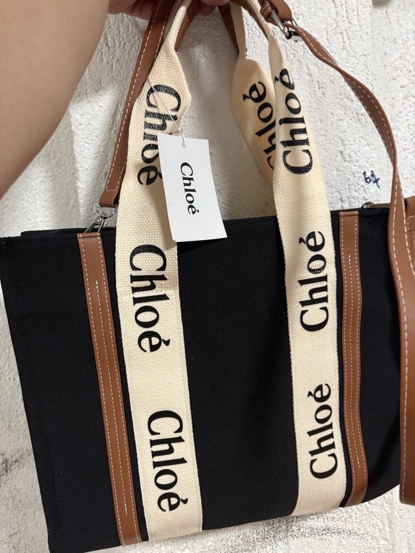 Chloe Woody Tote Bag (Category: Luxury Bags & Wallets) located in Pulilan. Submitted by patty126 (Listing ID 1438614258, Image 1). Description: - Chloe Woody Tote Bag - Black canvas body - Beige straps with Chloe logo print - Brown leather trim - Spacious interior - Zipper closure - Detachable shoulder strap.