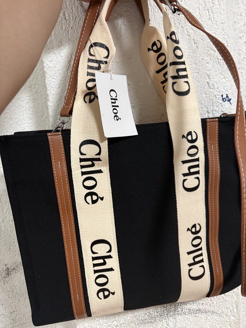 Chloe Woody Tote Bag (Category: Luxury Bags & Wallets) located in Pulilan. Submitted by patty126 (Listing ID 1438614258, Image 2). Description: - Chloe Woody Tote Bag - Black canvas body - Beige straps with Chloe logo print - Brown leather trim - Spacious interior - Zipper closure - Detachable shoulder strap.