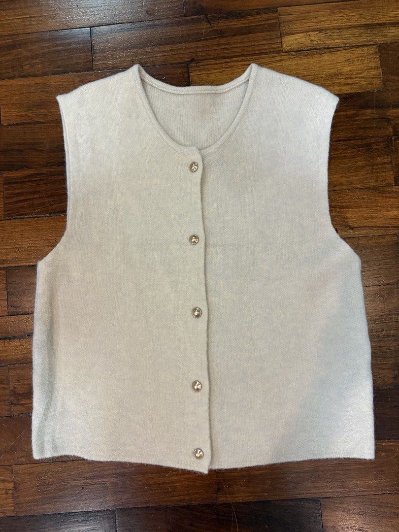 Cream-colored Sleeveless Knitted Vest with Buttons (Category: Sleeveless) located in Quezon City. Submitted by daphnelarissa (Listing ID 1438637021, Image 1). Description: - Cream-colored sleeveless vest - Round neckline - Button-down closure with decorative buttons - Simple, clean design - Suitable for layering - Soft material - Plain back Can fit until large body frames.