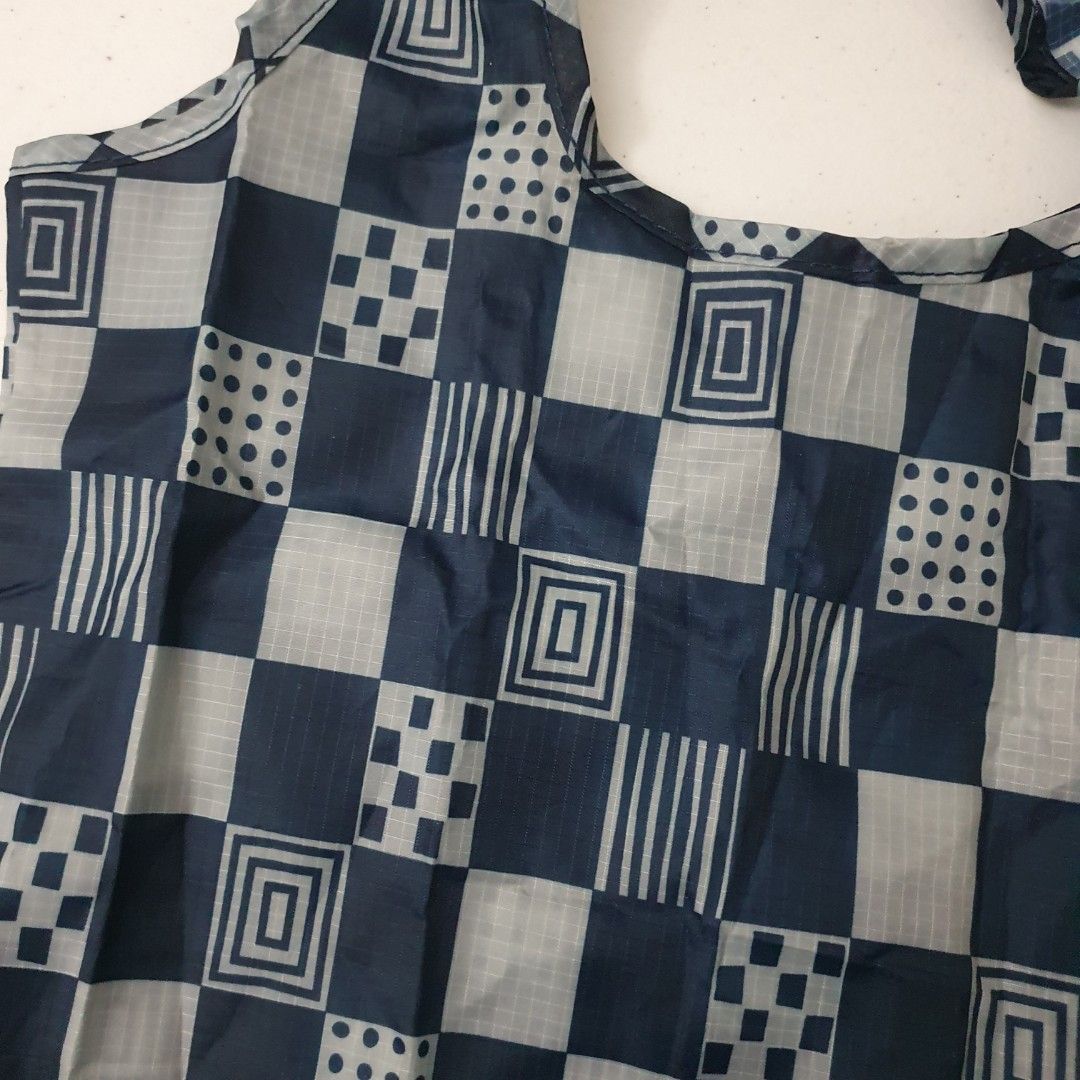 Foldable Shopping Bag - Checkered Pattern market bag eco bag (Category: Tote Bags) located in Paranaque City. Submitted by cobien (Listing ID 1438690372, Image 3). Description: - Stylish navy blue and gray checkered pattern - Foldable design for easy storage - Features two handles for comfortable carrying - Made of lightweight material (likely nylon) - Ideal for groceries, shopping, and eco-friendly use.