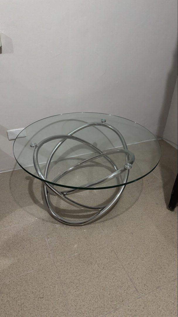 Glass Top Coffee Table - 24” (Category: Tables & Sets) located in Manila. Submitted by _anjdecluttermnl21 (Listing ID 1438554580, Image 1). Description: - Modern coffee table - Clear glass top - Unique intertwined metal base - Stylish design - Ideal for living rooms and lounges - Functional surface for drinks, books, or decor - Sleek glass top - Elegant metal base.