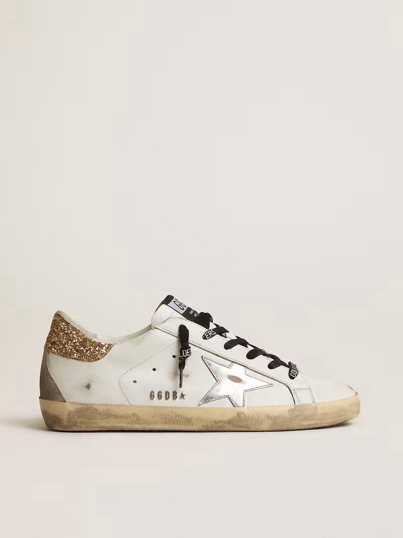Golden Goose Superstar Sneakers (Category: Sneakers) located in Baybay. Submitted by styleonpoint (Listing ID 1438518937, Image 1). Description: - Golden Goose Superstar sneakers - White leather upper - Glitter heel tab - Silver star detail - Distressed sole - Black laces - Brand name on side and tongue.
