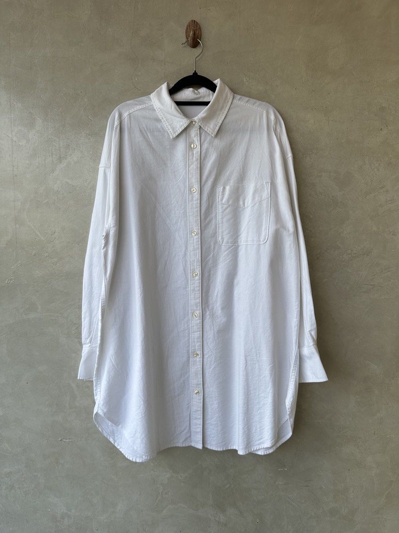 GU White Oversized Shirt - Size M (Category: Shirts) located in Cavite. Submitted by hand.picked (Listing ID 1438627699, Image 2). Description: - GU white oversized shirt - Features: Classic collar, button-down, chest pocket - Sleeves: Long with buttoned cuffs - Fit: Relaxed, longer length - Fabric: Lightweight - Ideal for casual wear - Oxford Size: Medium Dimension: 23” Width / 34” Length Condition: Excellent.