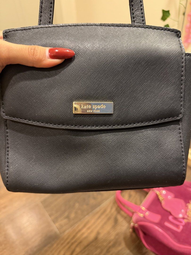 Kate Spade Black Handbag (Category: Luxury Bags & Wallets) located in Quezon City. Submitted by lililiadluns (Listing ID 1438584292, Image 2). Description: - Black Kate Spade handbag - Top handle and detachable shoulder strap - Flap closure with gold-tone logo - Structured shape - Textured material - Small size.