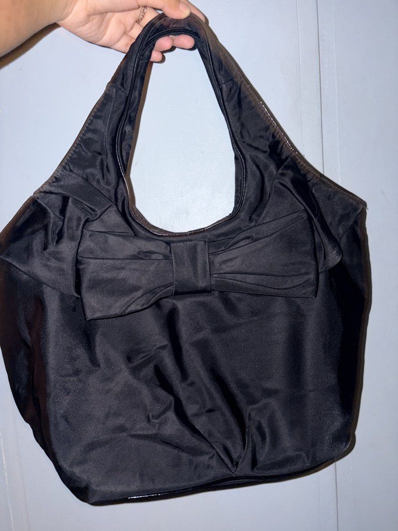Kate Spade Black Tote Bag (Category: Tote Bags) located in Manila. Submitted by love.hazey (Listing ID 1438637133, Image 1). Description: - Kate Spade black tote bag - Large bow detail on front - Patterned interior lining - Interior zippered pocket - Exterior Kate Spade label - Shoulder strap - Zippered closure.