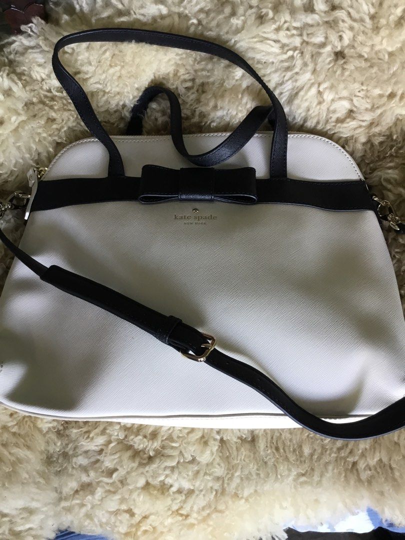 Kate Spade Bow Satchel Bag (Category: Luxury Bags & Wallets) located in Las Pinas. Submitted by starlacollection (Listing ID 1438688318, Image 1). Description: - Kate Spade satchel bag - Cream body with black accents - Stylish bow detail - Top handle and detachable shoulder strap - Secure zipper closure - Black interior - Dimensions: Approximately 14 inches (W) x 11 inches (H).
