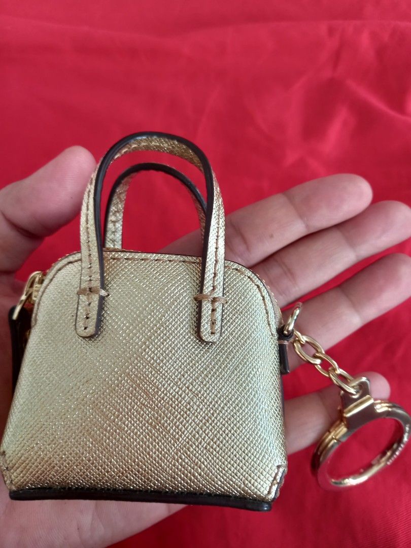 Kate Spade Gold Handbag Key Chain (Category: Luxury Bags & Wallets) located in Tuguegarao City. Submitted by zenphoenix-7ad615 (Listing ID 1438565041, Image 2). Description: - Kate Spade keychain - Mini handbag design - Gold color - Top handle - Zipper closure - Gold-tone ring - Kate Spade logo.