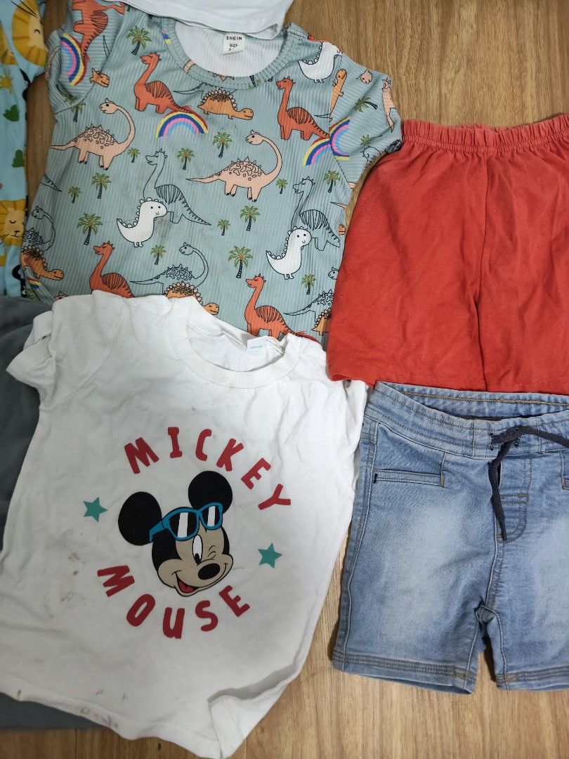 Kids' T-shirts and Shorts Bundle (Category: Babies & Kids Fashion) located in Mandaluyong City. Submitted by derekalava (Listing ID 1438560724, Image 3). Description: Bundle of kids' clothing including various t-shirts and shorts. Features a Mickey Mouse shirt, a shirt with the name "Rocho", and shirts with animal and vehicle prints. Includes denim shorts, red shorts, and patterned shorts. Perfect for everyday wear. if interested please call txt 