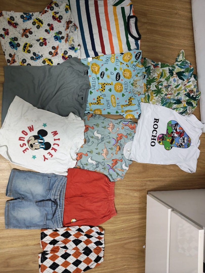 Kids' T-shirts and Shorts Bundle (Category: Babies & Kids Fashion) located in Mandaluyong City. Submitted by derekalava (Listing ID 1438560724, Image 1). Description: Bundle of kids' clothing including various t-shirts and shorts. Features a Mickey Mouse shirt, a shirt with the name "Rocho", and shirts with animal and vehicle prints. Includes denim shorts, red shorts, and patterned shorts. Perfect for everyday wear. if interested please call txt 