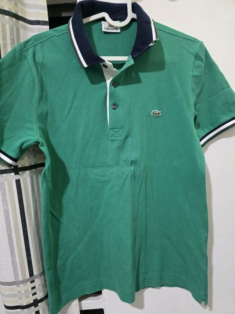Lacoste Green Polo Shirt (Category: Tshirts & Polo Shirts ) located in Angeles City. Submitted by gob_00 (Listing ID 1438671296, Image 1). Description: - Classic Lacoste polo shirt - Vibrant green color - Navy blue collar with white trim - Iconic Lacoste logo on chest - Short sleeves with white trim - Button-up placket - Size tag visible - Perfect for a casual, stylish look rfs: decluttering .