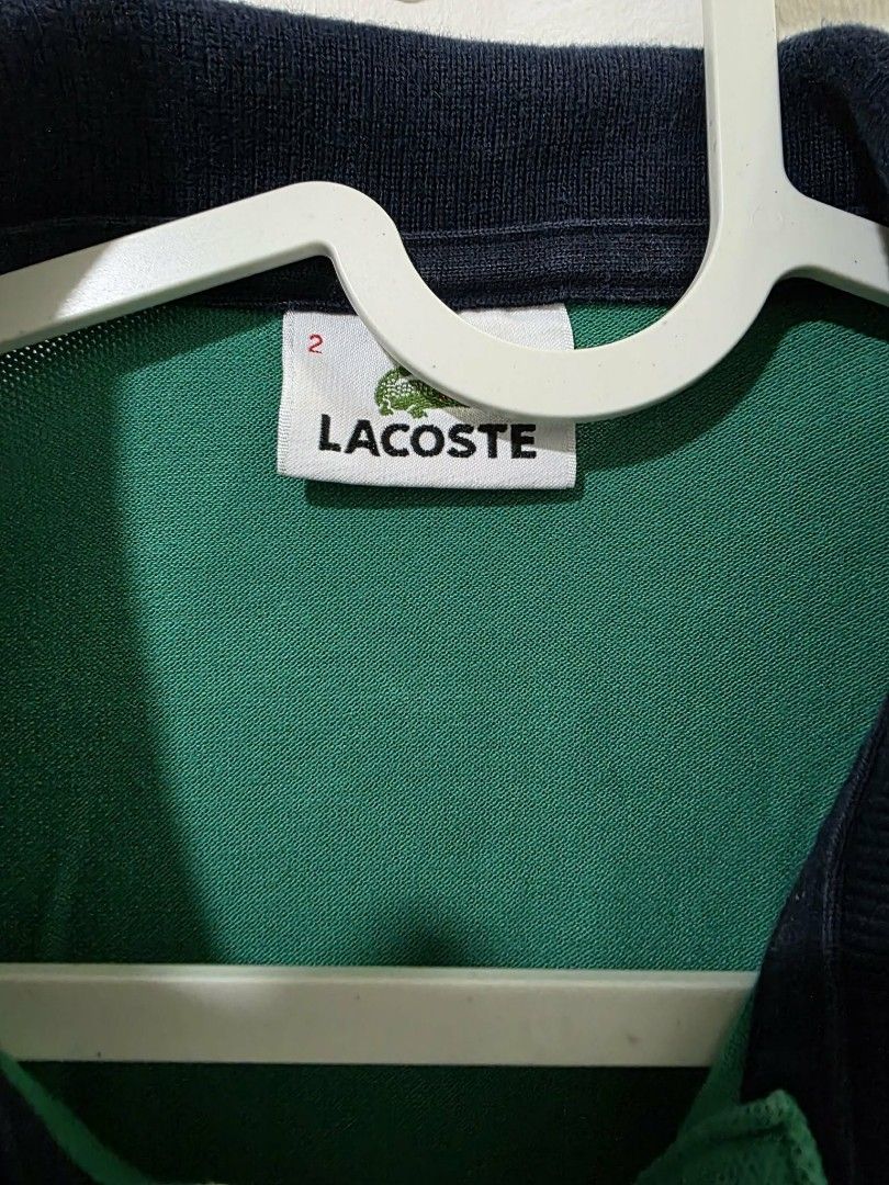 Lacoste Green Polo Shirt (Category: Tshirts & Polo Shirts ) located in Angeles City. Submitted by gob_00 (Listing ID 1438671296, Image 2). Description: - Classic Lacoste polo shirt - Vibrant green color - Navy blue collar with white trim - Iconic Lacoste logo on chest - Short sleeves with white trim - Button-up placket - Size tag visible - Perfect for a casual, stylish look rfs: decluttering .