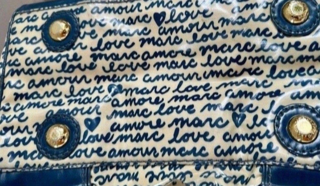 Marc by Marc Jacobs Love Amour Handbag (Category: Purses & Pouches) located in Quezon City. Submitted by kcobs (Listing ID 1438649327, Image 2). Description: - Cream-colored fabric - Authentic Marc Jacobs doctors bag - Navy blue "love amour marc" print - Navy blue handles and trim - Brand name metal plate - Rectangular shape - Zipper closure.