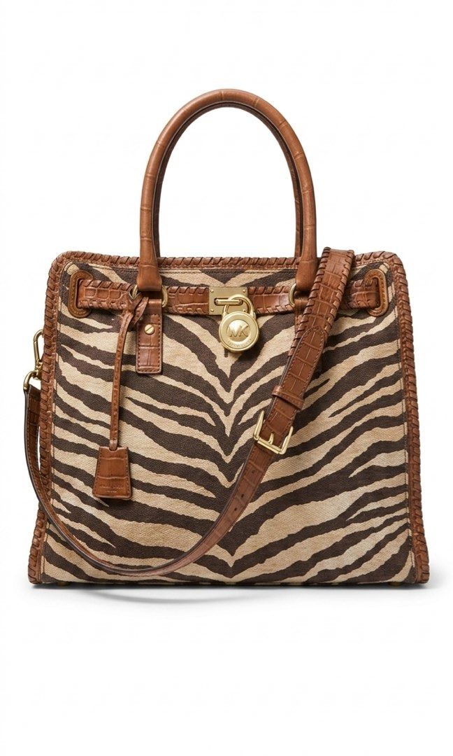 Michael Kors Zebra Hamilton Bag (Category: Luxury Bags & Wallets) located in Quezon City. Submitted by luv4luxxe (Listing ID 1404744309, Image 1). Description: Michael Kors Hamilton bag features a striking zebra print design. It has a top handle and a detachable shoulder strap. The bag is accented with brown leather trim and a gold-tone lock closure..