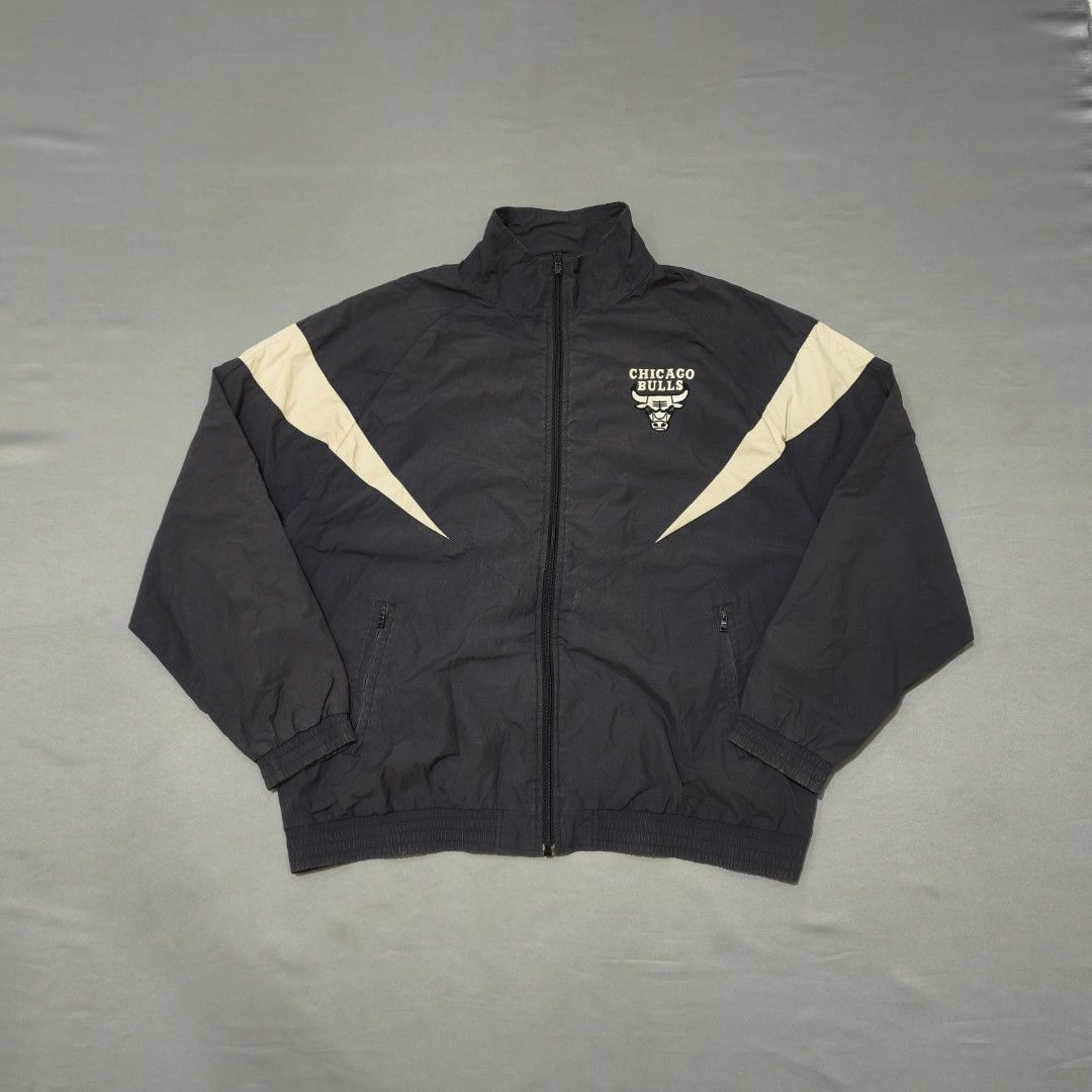 NBA Chicago Bulls Windbreaker Jacket (Category: Coats, Jackets and Outerwear) located in Cebu City. Submitted by greedthrift.00 (Listing ID 1438670092, Image 2). Description: - condition: 9.8/10 - color rate: 9.8/10 - dimes : 25.5 x 28.5 - Issue: none Black jacket with beige accents and Chicago Bulls logo. Lightweight material, full zip, high collar, and two front pockets..