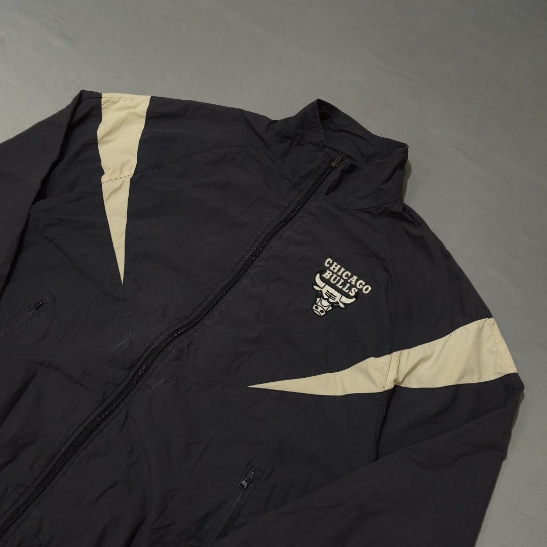 NBA Chicago Bulls Windbreaker Jacket (Category: Coats, Jackets and Outerwear) located in Cebu City. Submitted by greedthrift.00 (Listing ID 1438670092, Image 1). Description: - condition: 9.8/10 - color rate: 9.8/10 - dimes : 25.5 x 28.5 - Issue: none Black jacket with beige accents and Chicago Bulls logo. Lightweight material, full zip, high collar, and two front pockets..