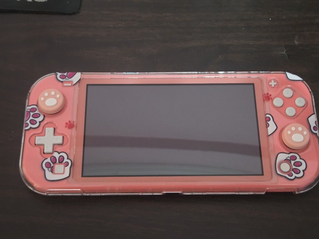 Nintendo Switch Lite Coral with Cat Case (Category: Nintendo) located in Manila. Submitted by clodmnyu (Listing ID 1438576725, Image 2). Description: - Coral Nintendo Switch Lite console - Includes a cute cat-themed case - Case features paw prints and cat design - Package includes console and case.