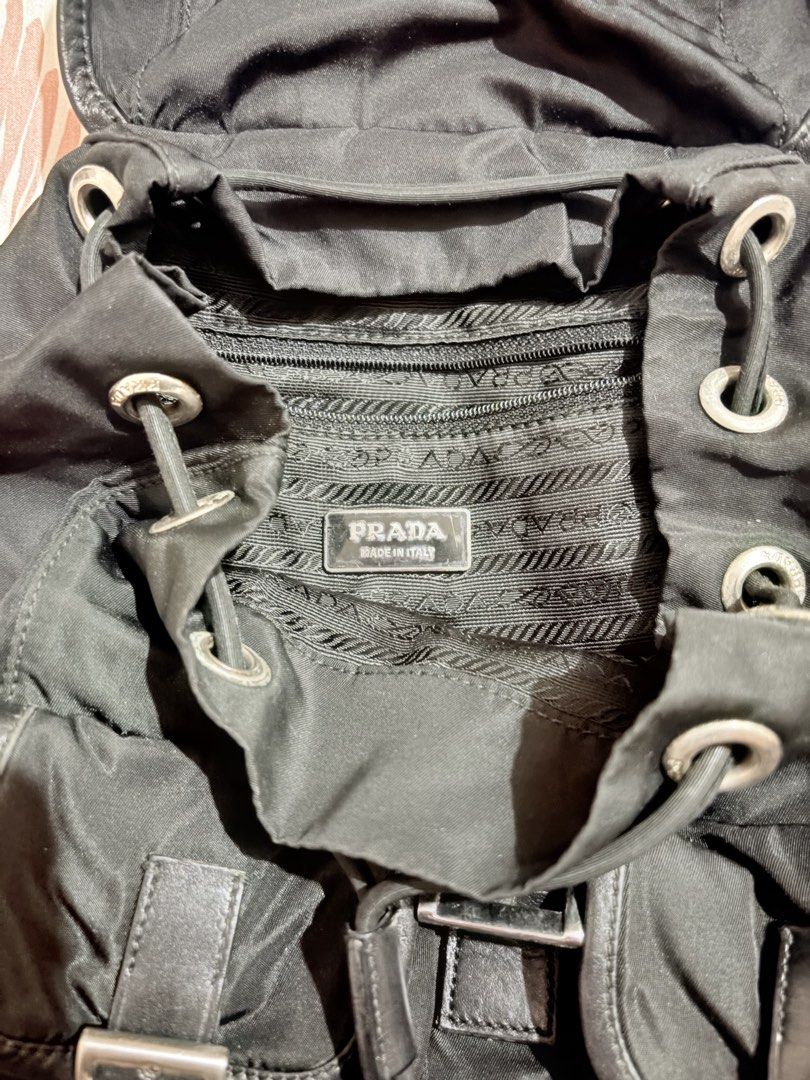 Prada Black Nylon Backpack (Category: Luxury Bags & Wallets) located in Las Pinas. Submitted by abbyraymun45954 (Listing ID 1438634819, Image 2). Description: - Authentic Prada backpack - Black nylon material - Flap closure with buckle - Two front pockets with buckles - Adjustable shoulder straps - Prada logo tag inside - Prada-branded hardware - Made in Italy.