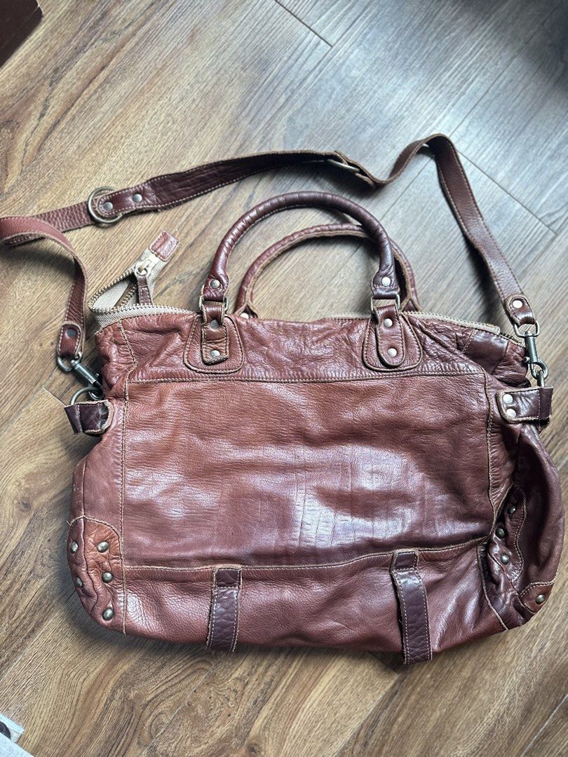Regalo Genuine Leather Handbag with Shoulder Strap (Category: Shoulder Bags) located in Mandaluyong City. Submitted by TheWeekendProject (Listing ID 1438559150, Image 2). Description: - Brown leather handbag - Detachable shoulder strap - Top zipper closure - Exterior pockets with buckle details - Top handle - Brown fabric interior lining - Includes a small tag - Metal studs on the sides - See last photo for price reference - Firm on price or for 