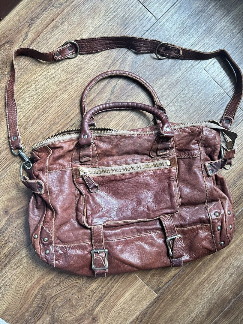 Regalo Genuine Leather Handbag with Shoulder Strap (Category: Shoulder Bags) located in Mandaluyong City. Submitted by TheWeekendProject (Listing ID 1438559150, Image 1). Description: - Brown leather handbag - Detachable shoulder strap - Top zipper closure - Exterior pockets with buckle details - Top handle - Brown fabric interior lining - Includes a small tag - Metal studs on the sides - See last photo for price reference - Firm on price or for 