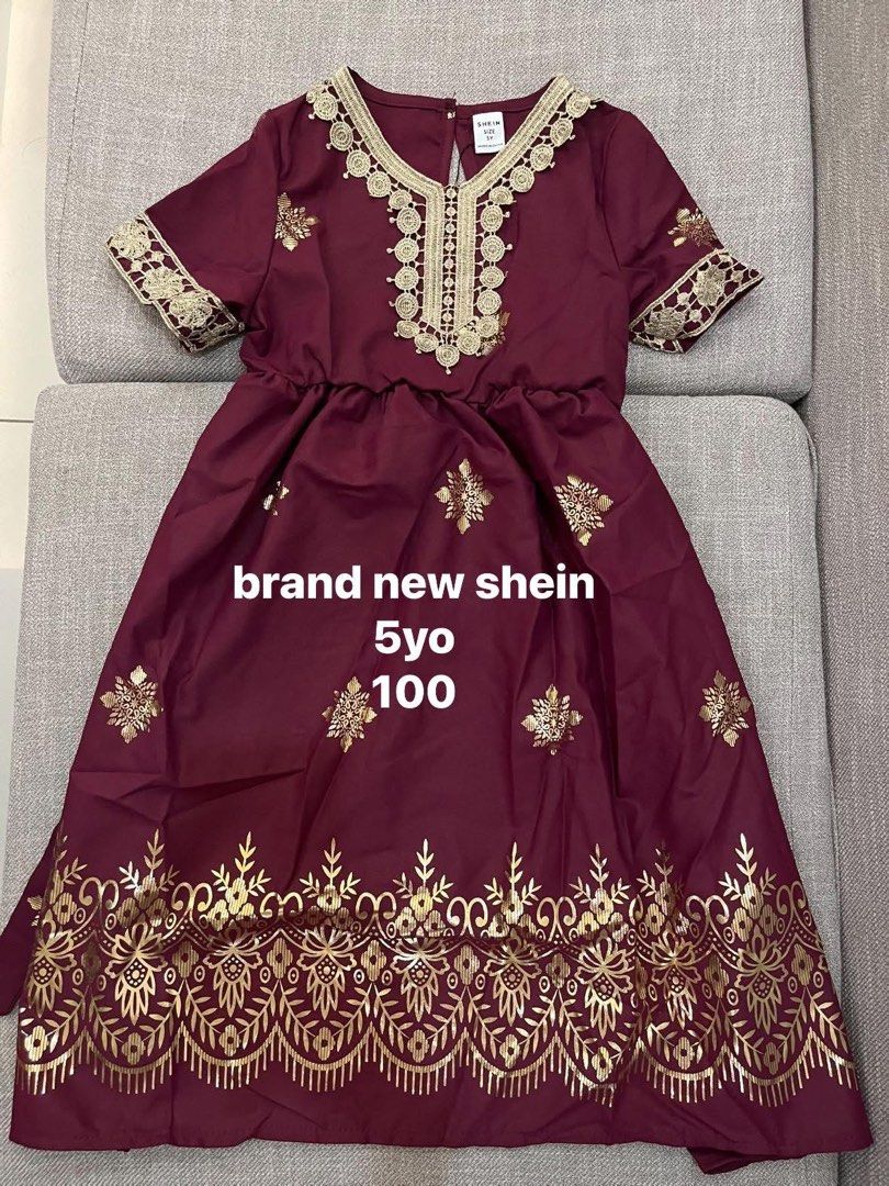 Shein Embroidered Dress - 5yo (Category: Babies & Kids Fashion) located in Taguig. Submitted by mm__ks888 (Listing ID 1438526989, Image 1). Description: - Shein dress, size 100 (fits a 5-year-old). - Maroon fabric with beautiful gold embroidery. - Features a round neckline with gold detailing. - Short sleeves. - Cinched waist for a flattering fit. - Flowing skirt with additional gold embroidery..