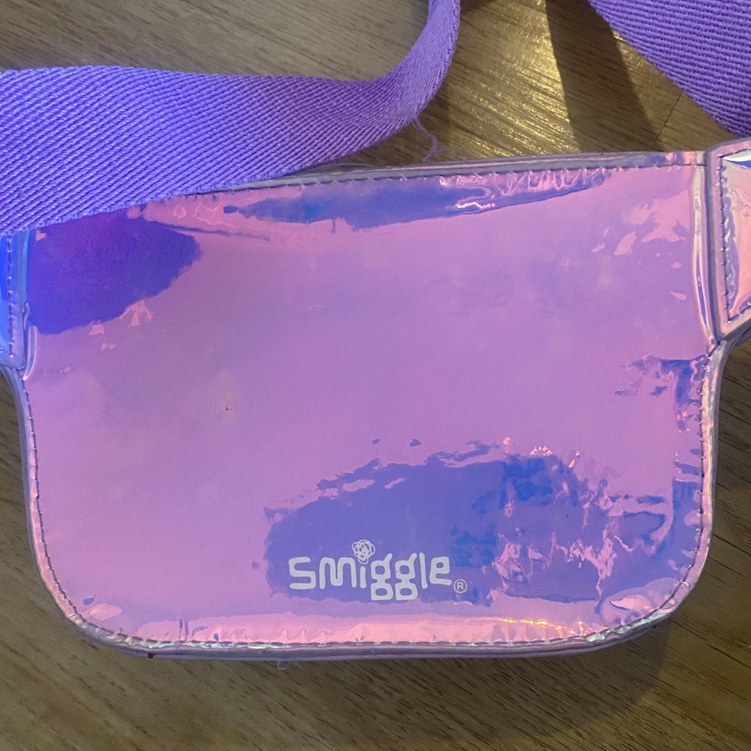 Smiggle Mermaid Waist Bag (Category: Babies & Kids Fashion) located in Paranaque City. Submitted by kalattt (Listing ID 1438559679, Image 2). Description: - Smiggle mermaid waist bag - Purple and iridescent design - Zippered main compartment - Adjustable strap - Adorned with seashell and star patterns - Smiggle logo visible.