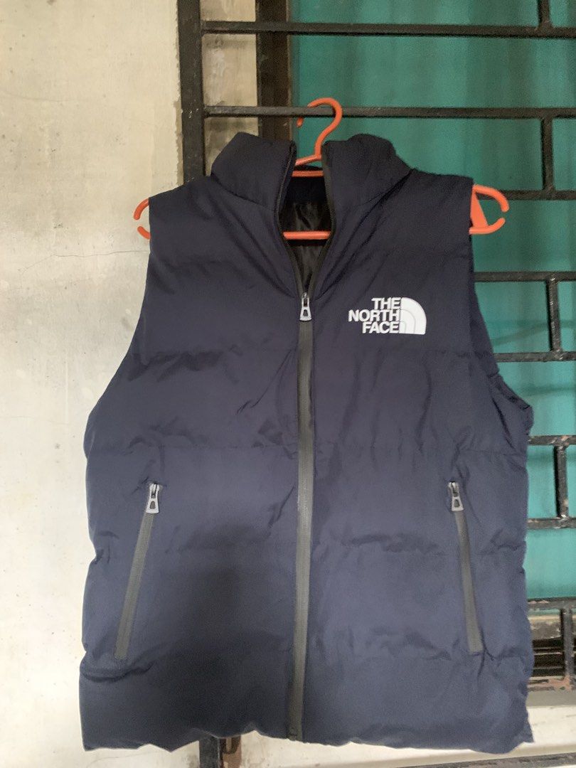 The North Face Puffer Vest (Category: Vests) located in Manila. Submitted by stashflip (Listing ID 1438689370, Image 3). Description: - Navy blue The North Face puffer vest - Full-zip closure - Two zippered hand pockets - High collar - The North Face logo on chest - Well-padded for warmth - Sleeveless design.
