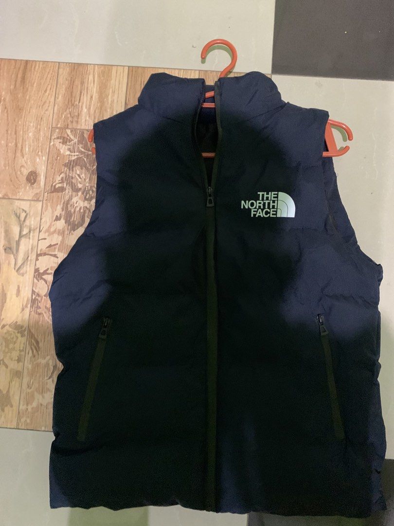 The North Face Puffer Vest (Category: Vests) located in Manila. Submitted by stashflip (Listing ID 1438689370, Image 1). Description: - Navy blue The North Face puffer vest - Full-zip closure - Two zippered hand pockets - High collar - The North Face logo on chest - Well-padded for warmth - Sleeveless design.