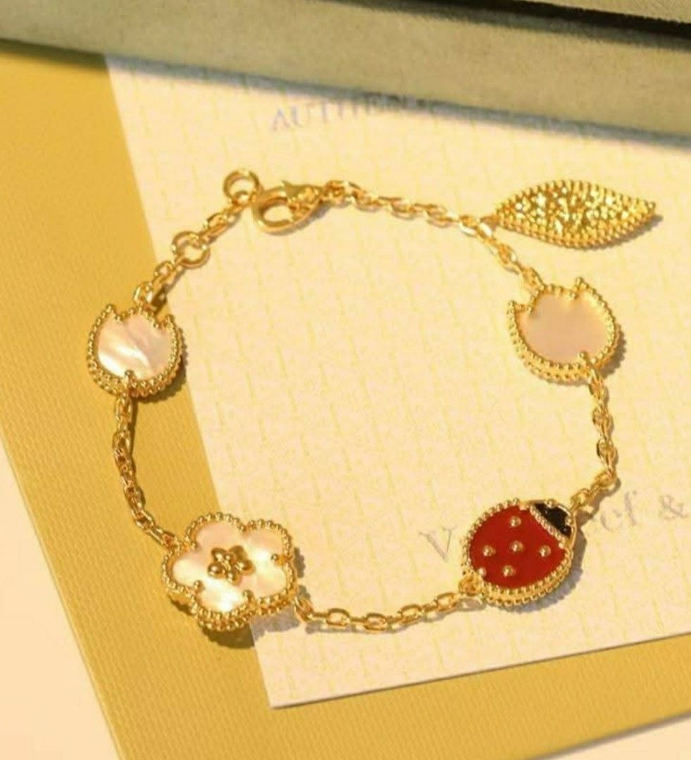 Van Cleef & Arpels Inspired Bracelet (Category: Bracelets) located in Manila. Submitted by poshcara (Listing ID 1438627912, Image 2). Description: - Gold chain stainless steel bracelet - Charms: flower, ladybug, leaf - Mother-of-pearl and red enamel details - Lobster clasp closure - Inspired by Van Cleef & Arpels design.