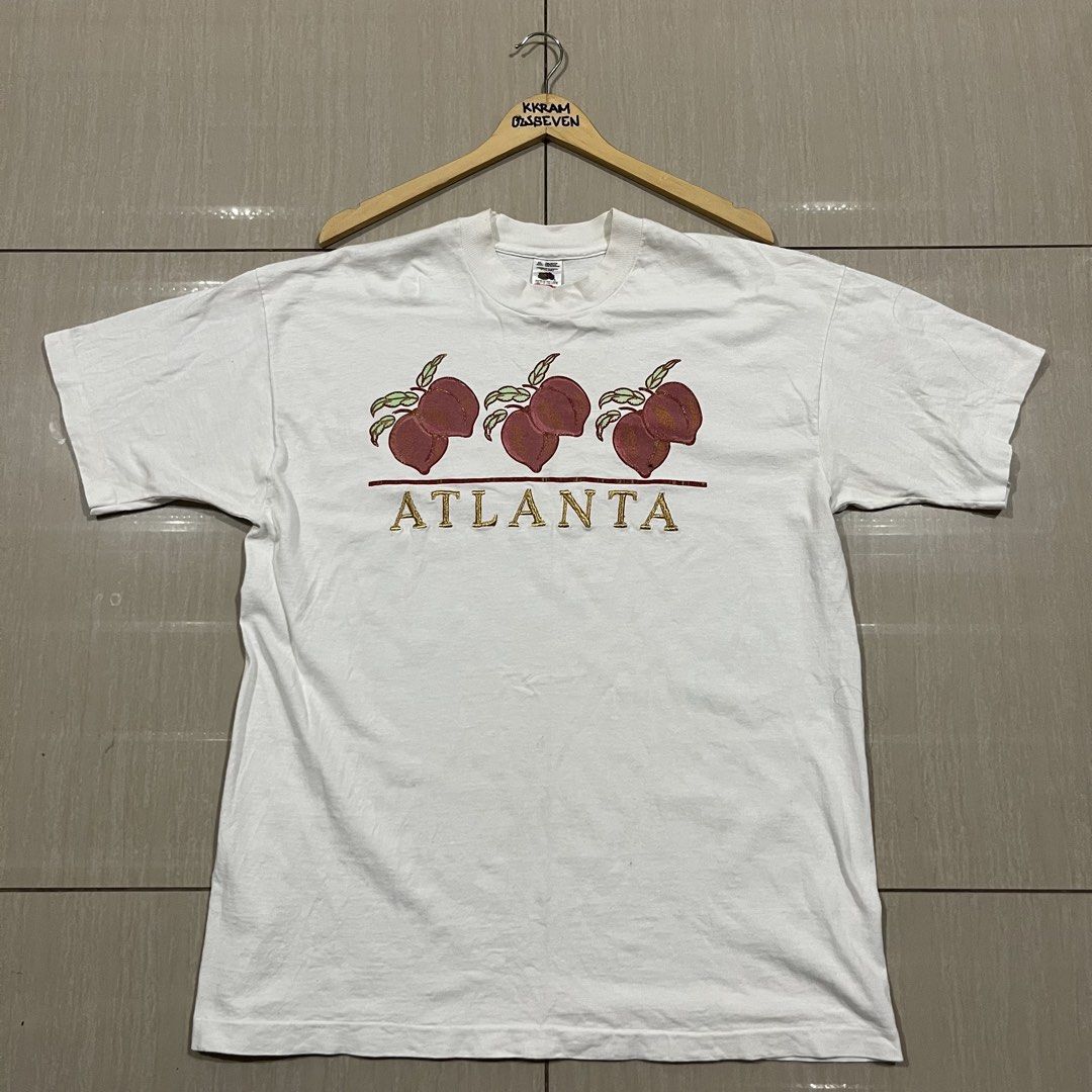 Vintage Atlanta Peach Graphic T-Shirt (Category: Tshirts & Polo Shirts ) located in Manila. Submitted by greedythrifts (Listing ID 1438535906, Image 1). Description: - Vintage Atlanta Peach T-shirt - White color - Features a gold 'ATLANTA' graphic and peach design - Crew neck and short sleeves - Brand: Fruit of the Loom.