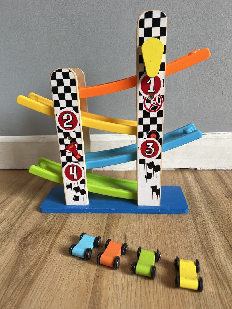 Wooden Race Track Toy (Category: Educational & Learning Toys) located in Quezon. Submitted by smallville.ph (Listing ID 1438563199, Image 1). Description: - Wooden race track with numbered lanes - Includes colorful cars (blue, orange, green, yellow) - Features a checkered flag design - Made of wood - Ideal for young children.
