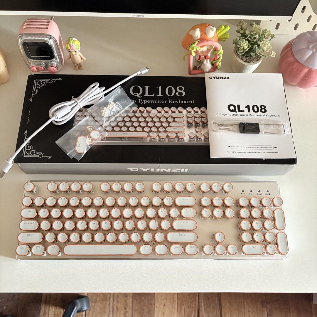 YUNZII QL108 Retro Typewriter-style Mechanical Keyboard (Category: Computer Keyboard) located in Manila. Submitted by patriciamaege (Listing ID 1438651588, Image 1). Description: COMPLETE SET WITH BOX - 100% layout - Wired connection (Type-C) - Hot swappable switches - Mac/Win/Android/iOS compatible - Foot support - 24 rgb backlight effects - Premium tactile and clicky sound Negotiable for sure buyers!.
