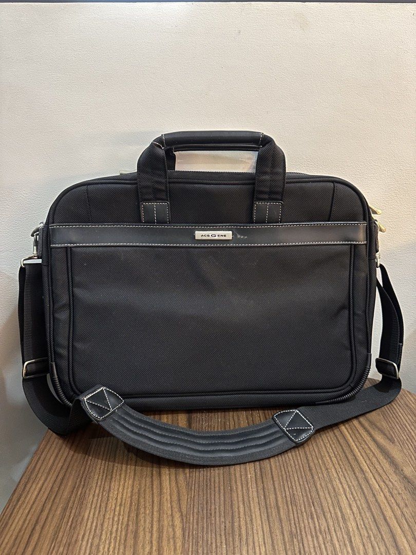 Ace Gene Black Laptop Bag (Category: Briefcases) located in Caloocan City. Submitted by kween.of.decluttering (Listing ID 1438842618, Image 1). Description: - Black Ace Gene briefcase - Includes a shoulder strap and top handle - Features multiple internal compartments - Secure zipper closure - Padded shoulder strap for comfort - Minor wear on metal hardware.