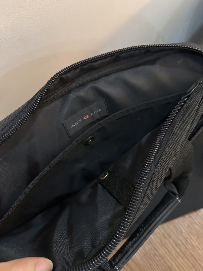 Ace Gene Black Laptop Bag (Category: Briefcases) located in Caloocan City. Submitted by kween.of.decluttering (Listing ID 1438842618, Image 2). Description: - Black Ace Gene briefcase - Includes a shoulder strap and top handle - Features multiple internal compartments - Secure zipper closure - Padded shoulder strap for comfort - Minor wear on metal hardware.