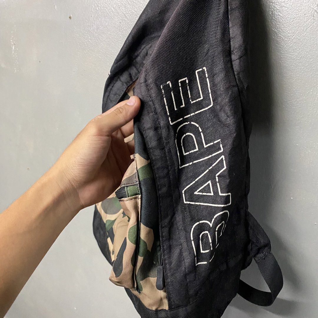 BAPE Camo Backpack (Category: Backpacks) located in Cagayan de Oro. Submitted by sumamestreethub (Listing ID 1438838851, Image 2). Description: - Authentic BAPE backpack - Distinctive camo pattern on front pocket - Black body with BAPE logo - Top handle and adjustable shoulder straps - Front pocket and spacious main compartment - Clean and well-maintained interior.