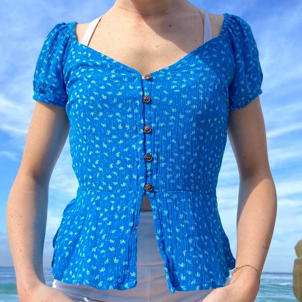 Blue Floral Button-Up Top (Category: Blouses) located in Manila. Submitted by kat_declutter (Listing ID 1438740589, Image 1). Description: -photos when worn are not mine, got it for your reference (ctto) - Blue floral top - Button-up design - Short, puffed sleeves - Flattering peplum hem - V-neckline - Textured fabric - Fitted silhouette - Lightweight material.