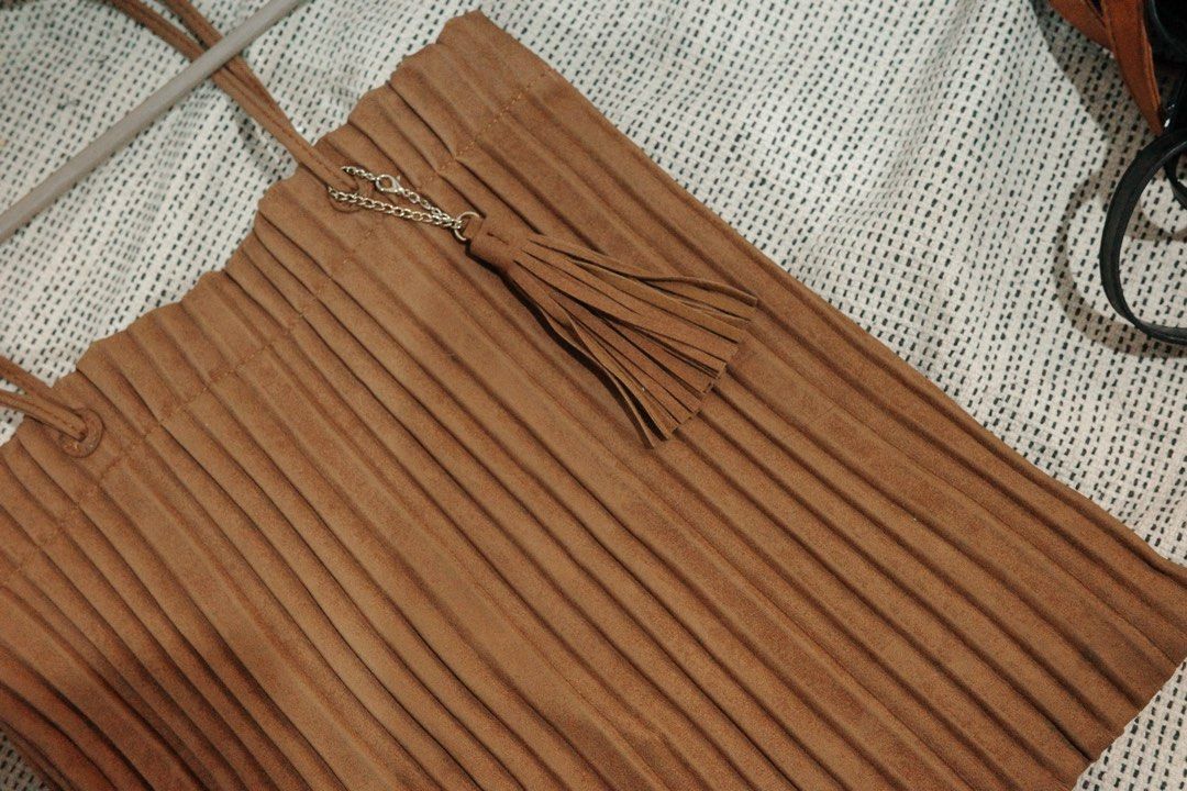 Brown Pleated Tote Bag with Tassel (Category: Tote Bags) located in Quezon City. Submitted by decluttering.neyns (Listing ID 1438713029, Image 2). Description: - Stylish brown tote bag - Pleated design - Magnetic snap closure - drak brown interior lining - Small interior zippered pocket - Long straps for shoulder or hand carry - Decorative tassel and chain detail.