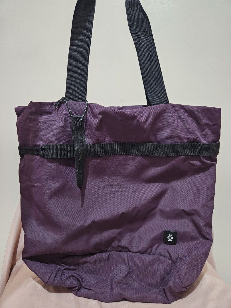 Crumpler Tote Bag (Category: Tote Bags) located in Taguig. Submitted by apriiiilll00 (Listing ID 1438821088, Image 1). Description: - Purple Crumpler tote bag - Black straps - Small Crumpler logo - Zippered pocket with light blue interior - Vertical zipper at the back - Drawstring closure - Authentic Crumpler tag.