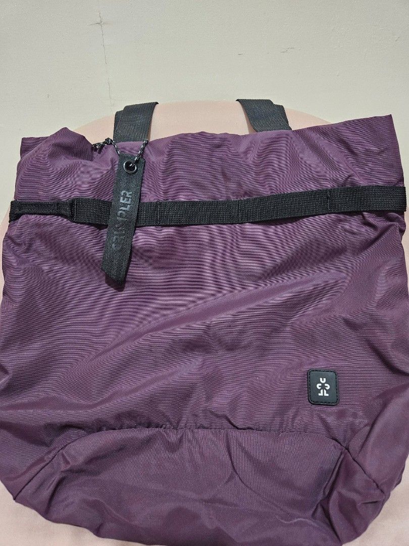 Crumpler Tote Bag (Category: Tote Bags) located in Taguig. Submitted by apriiiilll00 (Listing ID 1438821088, Image 2). Description: - Purple Crumpler tote bag - Black straps - Small Crumpler logo - Zippered pocket with light blue interior - Vertical zipper at the back - Drawstring closure - Authentic Crumpler tag.