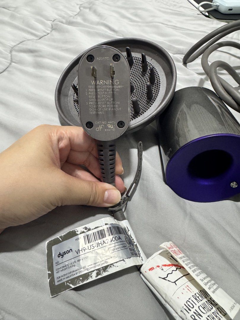 Dyson Supersonic Hair Dryer (Category: Hair) located in Quezon City. Submitted by nickole889510068 (Listing ID 1438814589, Image 3). Description: - Dyson Supersonic hair dryer - Color: Grey and Purple - Includes: Diffuser attachment, original power adapter - Model: VH9-US-JHA2400A - Features: Reset button, warning label on power cord 110 voltage bought in the US and haven’t used it much since moving here can be used with a transformer .