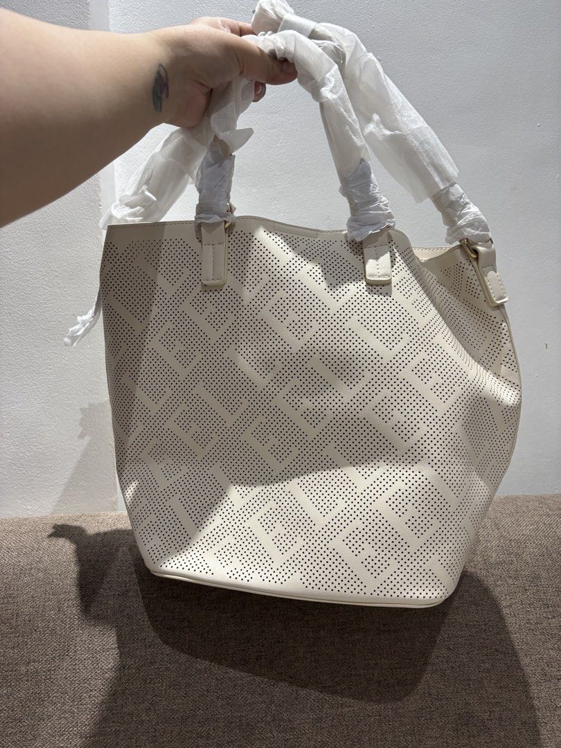 Elle Tote Bag (Category: Tote Bags) located in Mexico. Submitted by 3everything (Listing ID 1438821193, Image 2). Description: - Elle tote bag in cream color - Features: - Perforated design (one side) - Solid design (other side) - Includes: Dust bag and tags - Interior: Pocket and magnetic closure - Comes with: Handles and shoulder straps.