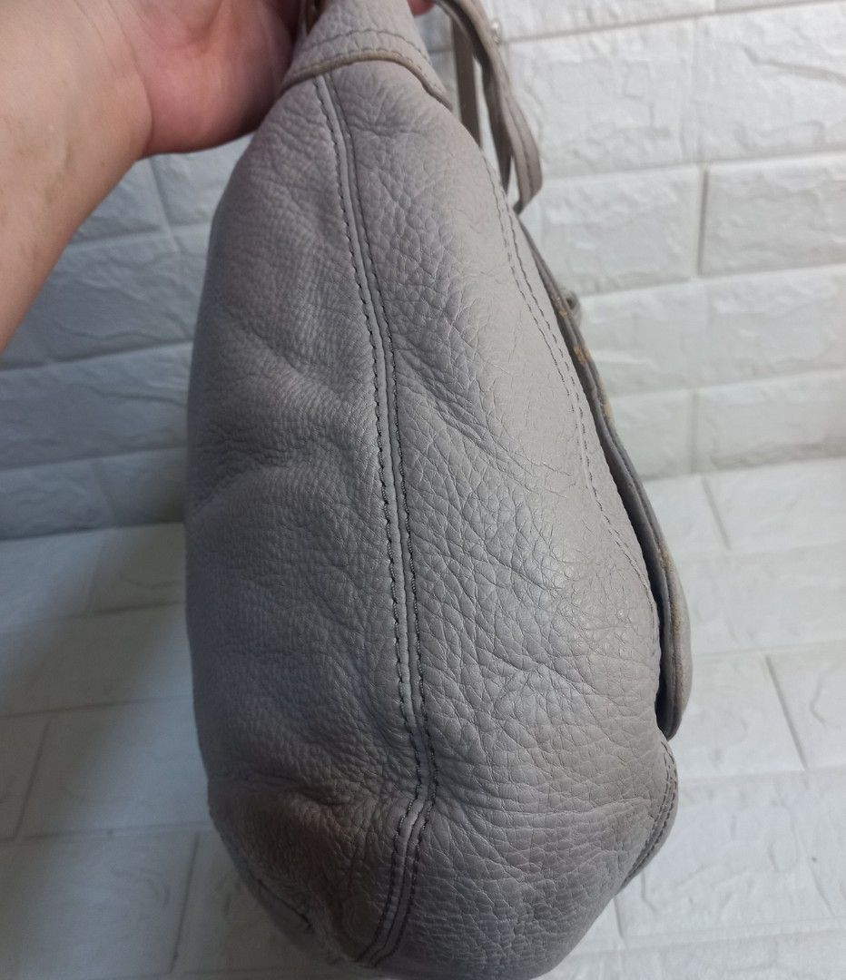 Fossil Karla Grey Leather Hobo Bag (Category: Shoulder Bags) located in Las Pinas. Submitted by etoksi1234 (Listing ID 1438757094, Image 3). Description: Pre-loved Fossil Karla Grey leather hobo bag with gold hardware. Features two front zip pockets and a single shoulder strap. Versatile, neutral color. With flaws on rubber lining..