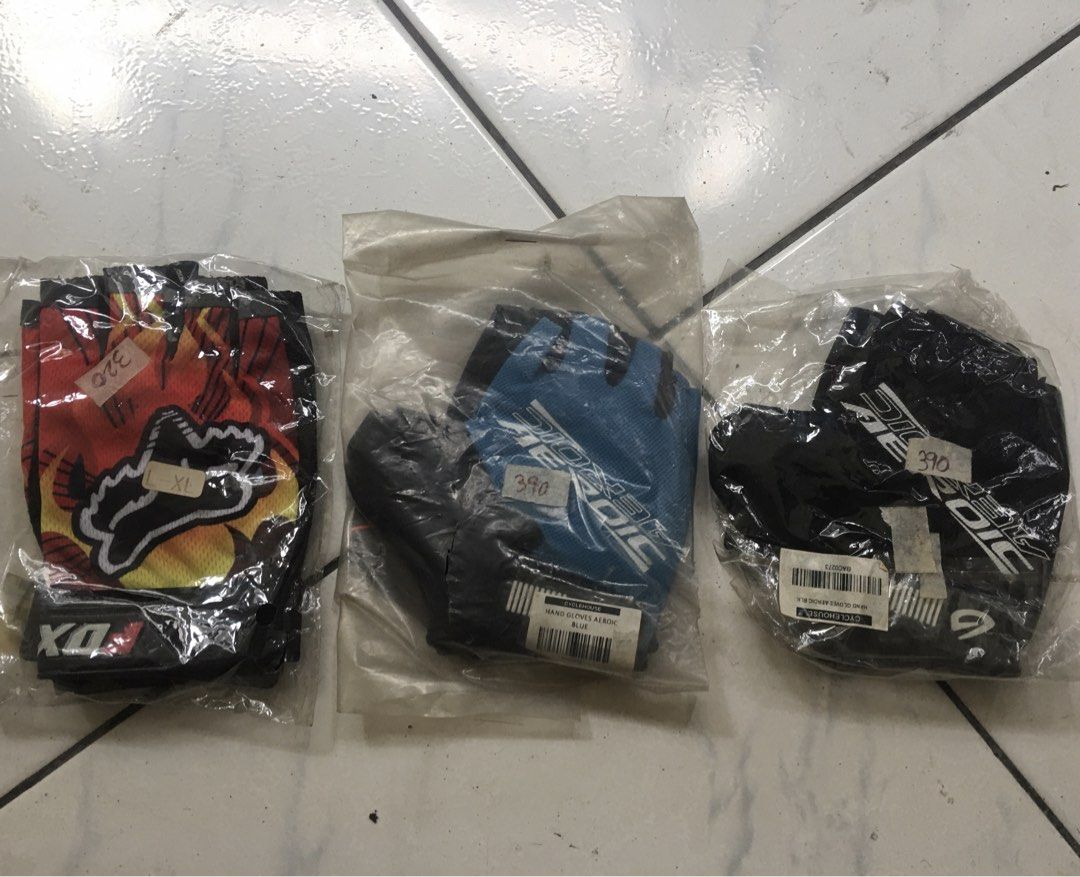 Fox DX XL Gloves / Aeroic Hand Gloves (Category: Other Sports Equipment and Supplies) located in San Juan City. Submitted by nel.ward.ed (Listing ID 1438763374, Image 1). Description: Set of three gloves. One pair is Fox DX XL, with a red, orange, and yellow design. The second pair is blue, and the third pair is black. All gloves are fingerless. Price tags are visible on each pair..