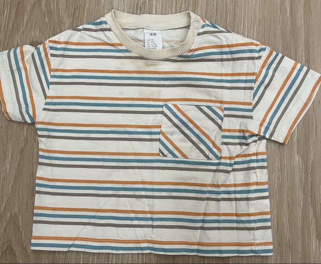 H&M Striped T-shirt - 9M (Category: Babies & Kids Fashion) located in Makati City. Submitted by riz.gspr (Listing ID 1438760922, Image 1). Description: - H&M baby t-shirt - Size: 74 (fits approximately 9 months) - Design: Striped with a pocket - Colors: Orange, blue, and gray stripes on a white background - Features: Short sleeves, round neckline.